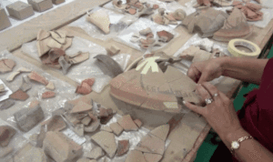 Screenshot from video report of excavated jar being pieced together